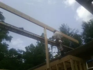 Carpenter setting a ridge beam over a new addition frame — Ice Dam Removal by Roofing Brothers in Seal Beach