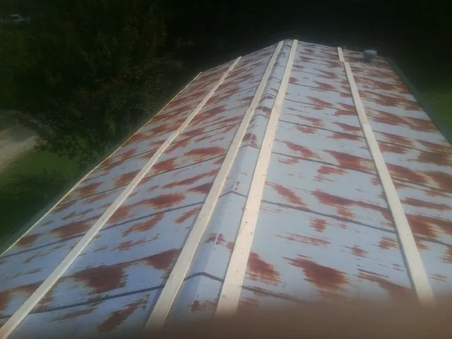 Rusted metal roof panels with new wood purlins before replacement — Storm Damage Roof Repair in Seal Beach by Roofing Brothers
